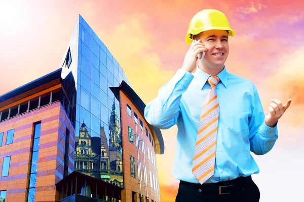 Mladý architekt, nosit ochrannou helmu stojící na budovy — Stock fotografie