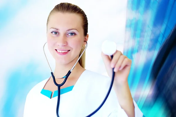 Medico sorridente con stetoscopio sul retro degli ospedali — Foto Stock