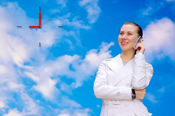 Счастливый звонок бизнес-леди по телефону на фоне неба — стоковое фото