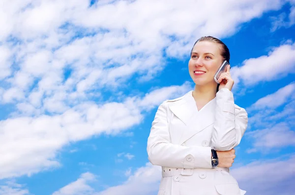 Щаслива бізнес-леді дзвонить по телефону на фоні неба — стокове фото