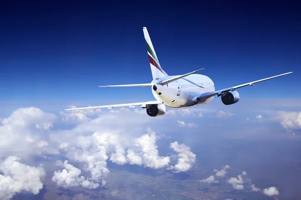 Airplane at fly on the sky with clouds — Stock Photo, Image