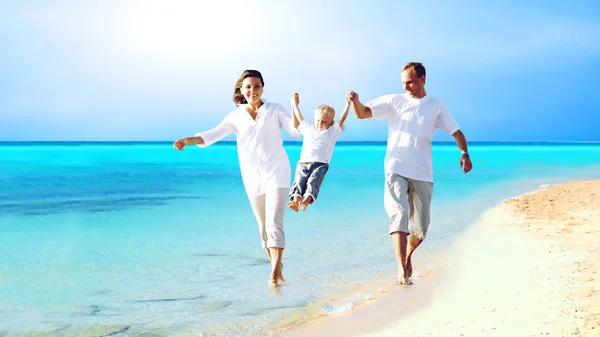 Visa glada unga familj att ha kul på stranden — Stockfoto