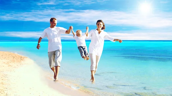 Άποψη της ευτυχισμένη νεαρή οικογένεια τη διασκέδαση στην παραλία — Φωτογραφία Αρχείου