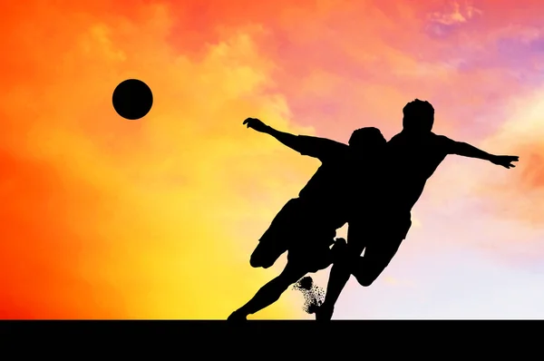 Napnyugtakor ég a labdarúgók sziluettek — Stock Fotó