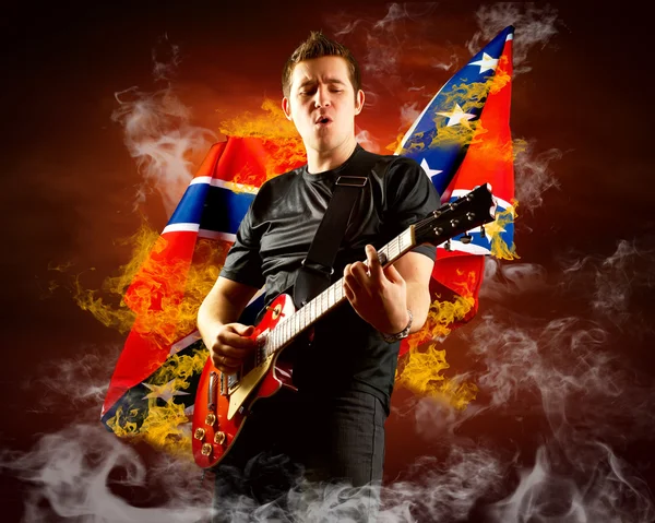 Guitarrista de rock toca en la guitarra eléctrica alrededor de llamas de fuego —  Fotos de Stock