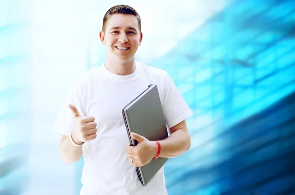 Χαρούμενος νεαρός ή φοιτητής με φορητό υπολογιστή και το τηλέφωνο για την επιχείρηση — Φωτογραφία Αρχείου
