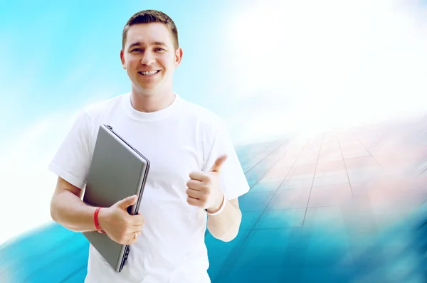 Giovane uomo felice o studente con computer portatile e telefono sul business — Foto Stock