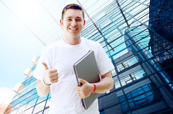 Молодой счастливый человек или студент с ноутбуком и телефоном на бизнес — стоковое фото