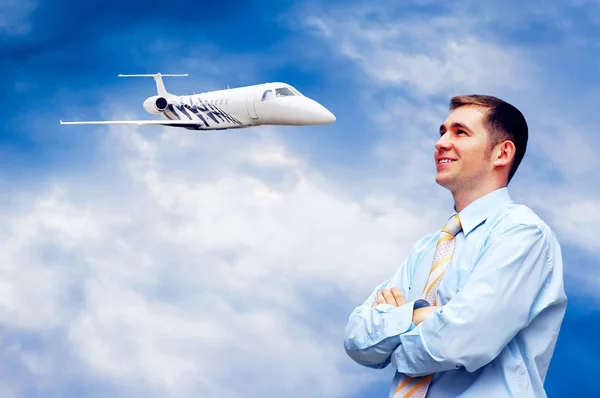 Щасливий бізнесмен на блакитному небі з літаком — стокове фото