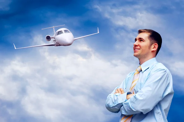 Glad affärsman på blå himmel med flygplan — Stockfoto