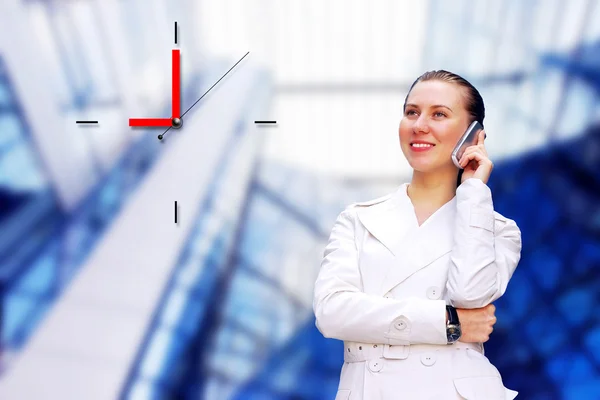 Felice business-donna chiamata per telefono su sfondo architettura aziendale — Foto Stock