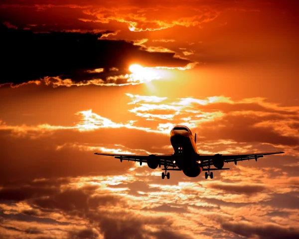 Napnyugtakor ég repülőgép — Stock Fotó
