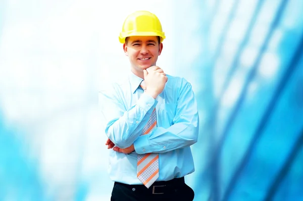 Молодой архитектор в защитном шлеме стоит на буиле — стоковое фото