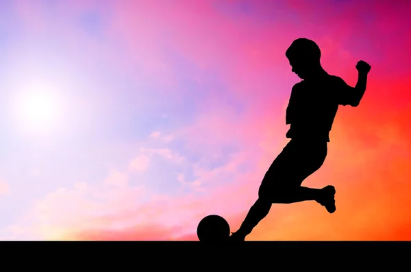 Silhouettes of footballers on the sunset sky — Stock Photo, Image