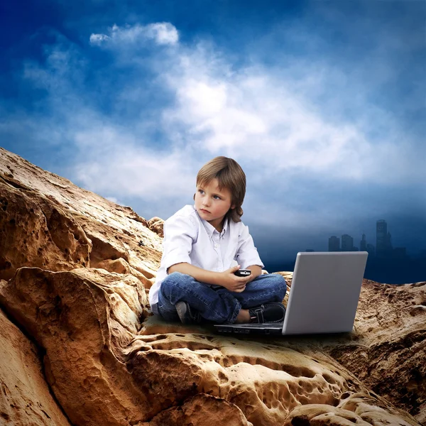 Child with laptop on the mauntain under sky with clouds — Stock Photo, Image