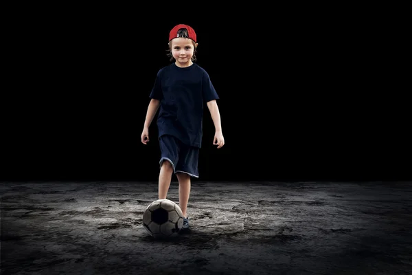 Giocatore di calcio bambino e palla Grunge sullo sfondo scuro — Foto Stock