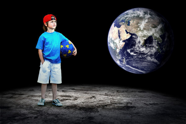 Child football player and Grunge ball on the dark background