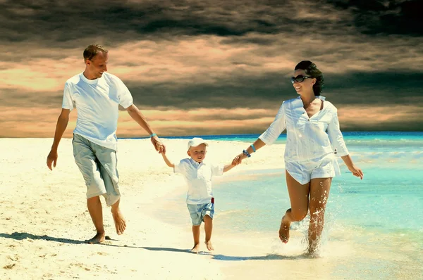 Nézd, a boldog fiatal család, szórakozás a strandon — Stock Fotó