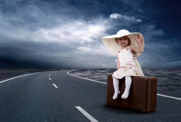 Liten flicka väntar på väg med hennes vintage bagage — Stockfoto