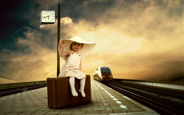 Μικρό κορίτσι που κάθεται στο vintage αποσκευών στην πλατφόρμα τραίνων του — Φωτογραφία Αρχείου