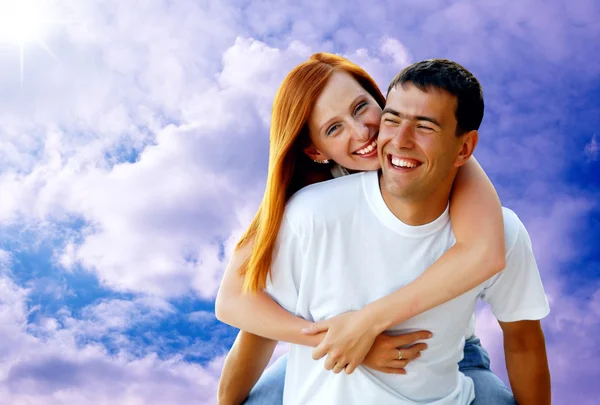 Young love couple smiling under blue sky — Stock Photo, Image