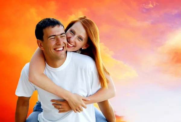 Fiatal szerelmes pár mosolygó kék ég alatt — Stock Fotó