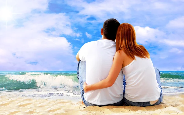 Vista mare di una coppia seduta sulla spiaggia . — Foto Stock