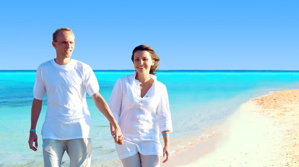 Pohled na šťastný mladý pár na pláži, drželi se za ruce. — Stock fotografie