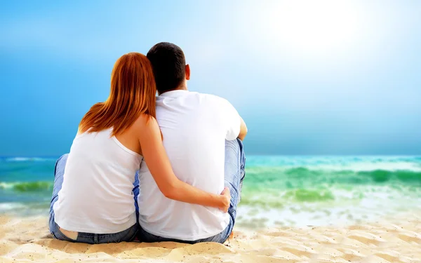 Sea view of a couple sitting on beach. — Stock Photo, Image