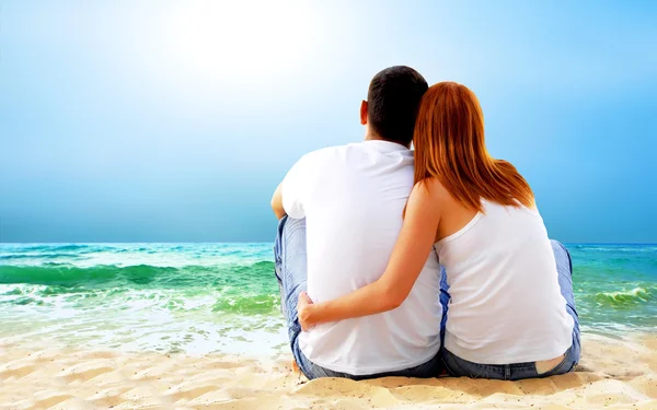 Vista al mar de una pareja sentada en la playa . — Foto de Stock