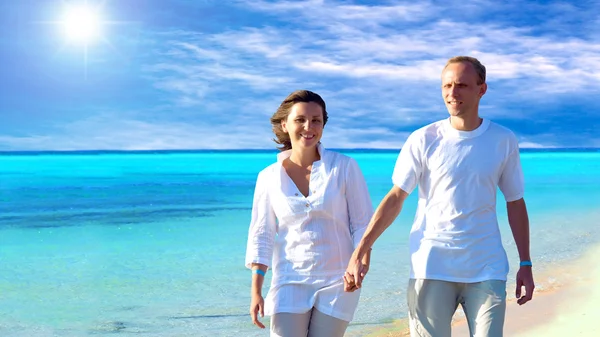Blick auf glückliches junges Paar, das am Strand spaziert und sich an den Händen hält. — Stockfoto