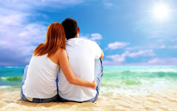 Havsutsikt över ett par sitter på stranden. — Stockfoto