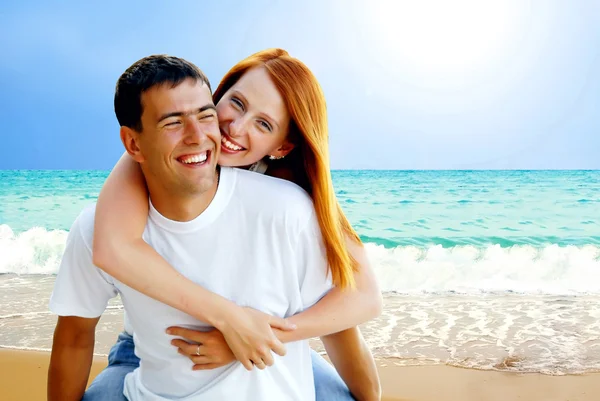 Молодая влюбленная пара улыбается под тропическим пляжем — стоковое фото