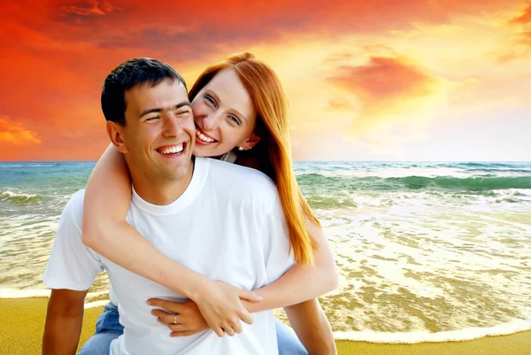Mladá láska pár usmívá pod tropickou pláž — Stock fotografie
