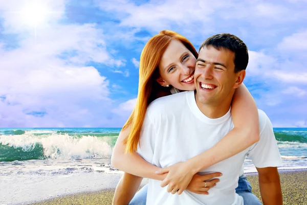 Joven pareja de amor sonriendo bajo la playa tropical —  Fotos de Stock