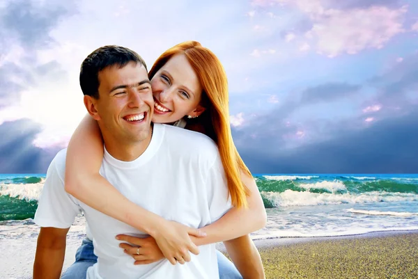 Mladá láska pár usmívá pod tropickou pláž — Stock fotografie