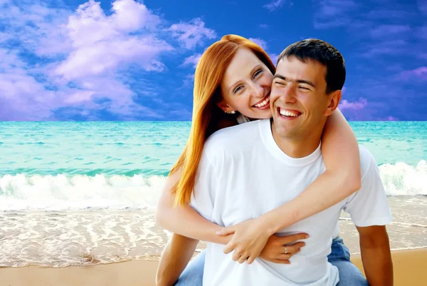 Joven pareja de amor sonriendo bajo la playa tropical — Foto de Stock