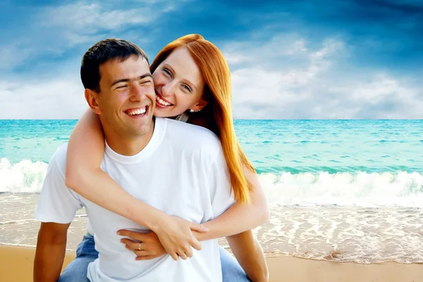 年轻的爱夫妇微笑下热带海滩 — 图库照片