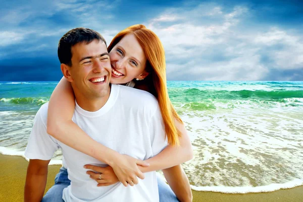 Jonge liefde paar glimlachend onder tropisch strand — Stockfoto