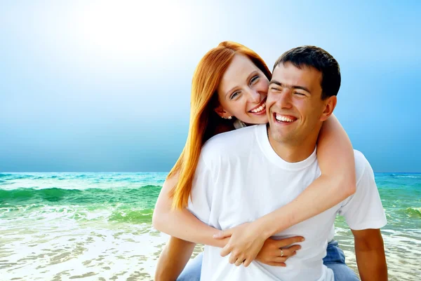 Para młoda miłość uśmiechający się na tropikalnej plaży — Zdjęcie stockowe
