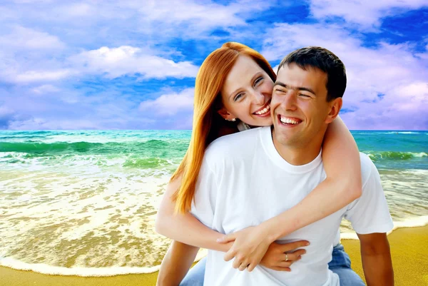 Junges Liebespaar lächelt unter tropischem Strand — Stockfoto