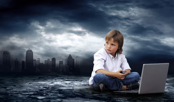 Crisis in world. Boy with laptop on dark sky with lightning — Stock Photo, Image