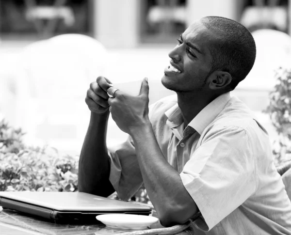 Jonge gelukkig man of student met laptop zitten aan de tafel — Stockfoto