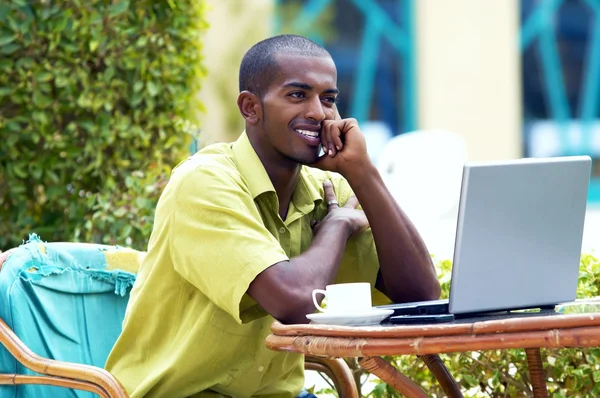Küçük mutlu bir adam ya da öğrenci ile masaya oturan laptop — Stok fotoğraf