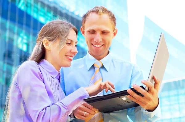 Felicità uomini d'affari con laptop su architettura aziendale sfocata — Foto Stock