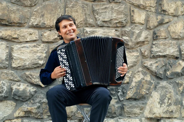 Male playing on the accordion against a grunge background — Stock Photo, Image