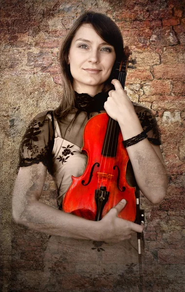 Hermosa violinista femenina con violín en el fondo grunge —  Fotos de Stock