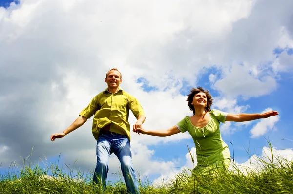 Fun couple in jump on the outdoor background — Stock Photo, Image