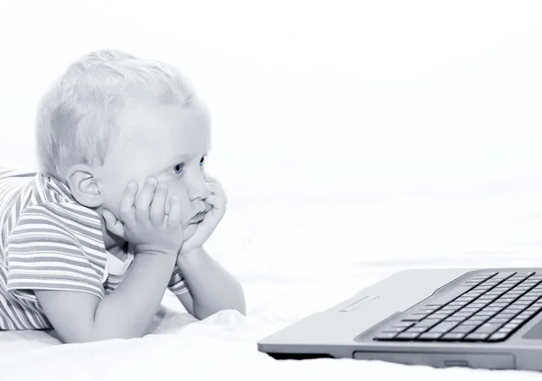 Счастливый мальчик имеет хорошую идею с ноутбуком — стоковое фото