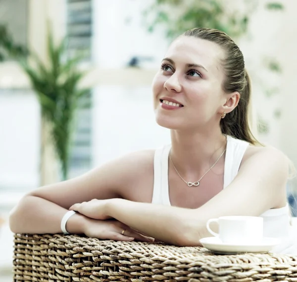 Счастливая женщина в белом с чашкой кофе или чая в спальне — стоковое фото
